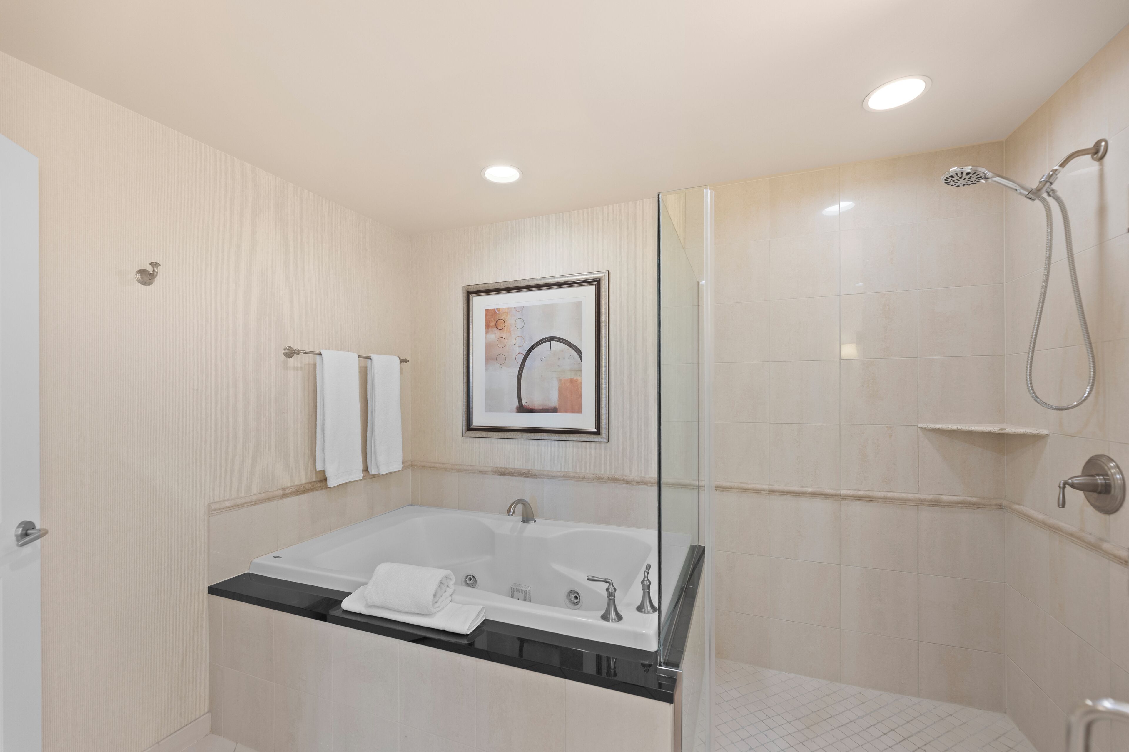 Ein modernes Badezimmer mit Badewanne, Dusche und einer gläsernen Duschkabine.