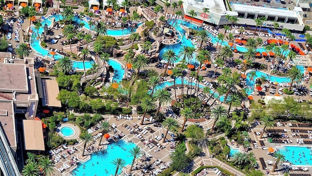 Vue aérienne d’un complexe hôtelier doté de plusieurs piscines, de palmiers et d’espaces de détente.