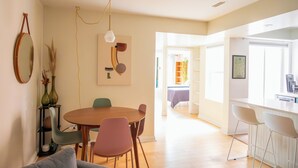 Een moderne eetruimte met een ronde tafel, stoelen en een hanglamp.