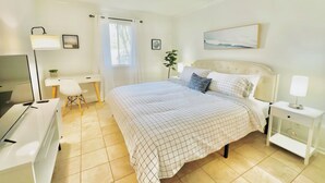 Ein Schlafzimmer mit Bett, Nachttischen, Schreibtisch und Stuhl.