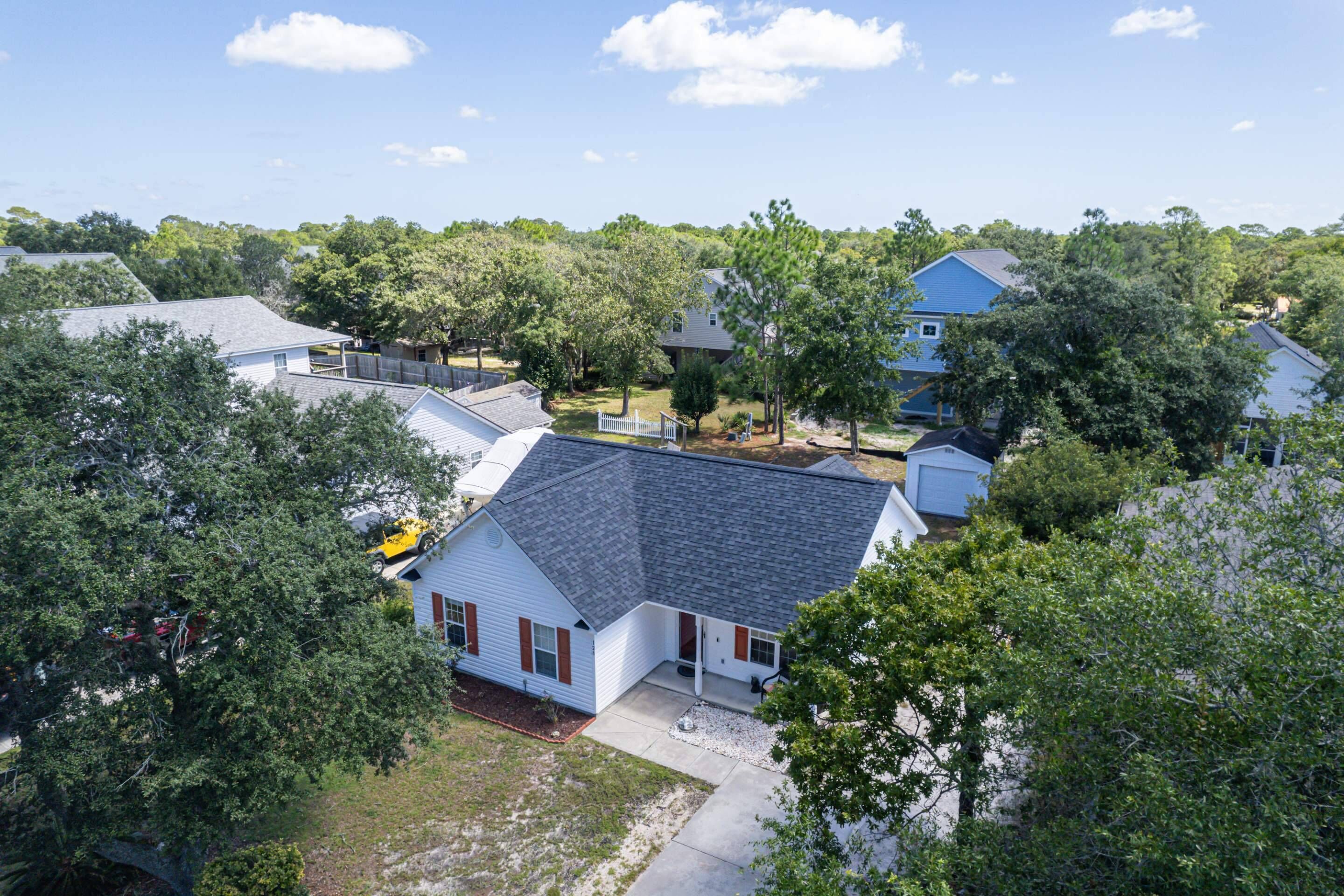 A residential area with houses surrounded by trees.