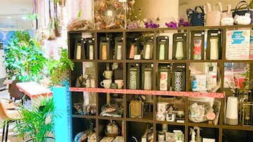 A store with shelves of various items, including bags and containers, and a table with chairs.