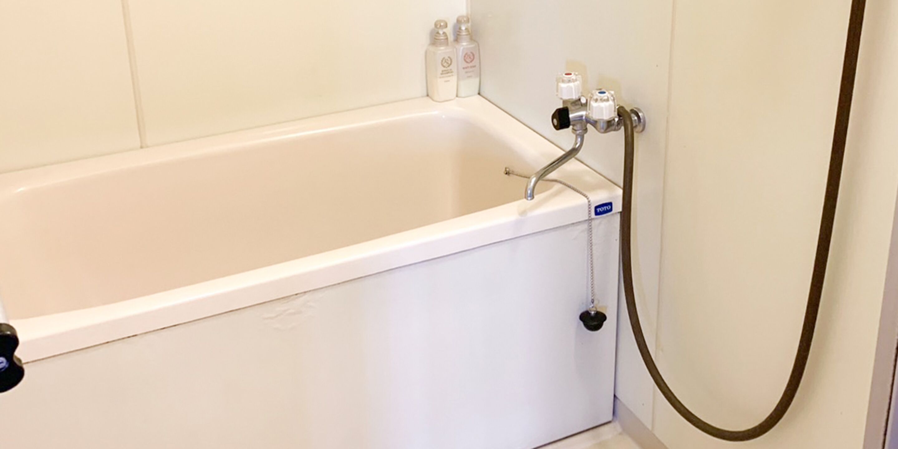 A white bathtub with a showerhead and control knobs.