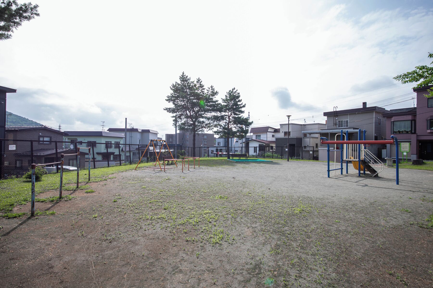 An outdoor playground with swings, a slide, and climbing structures.