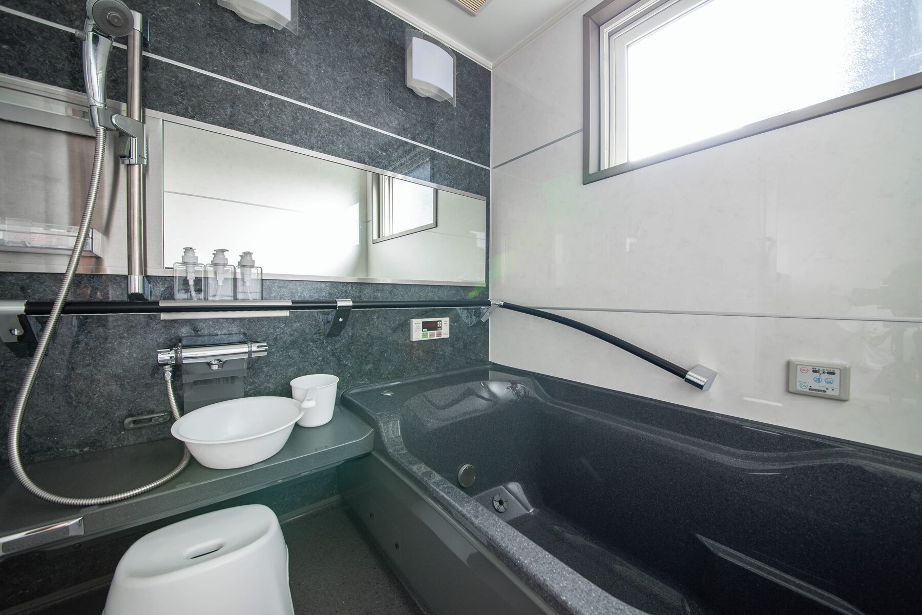 A modern bathroom with a bathtub, a sink, and a toilet.