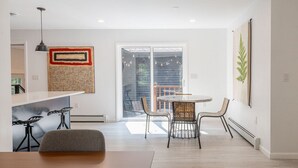Une cuisine moderne avec un coin repas, une grande fenêtre et une vue sur l’extérieur.