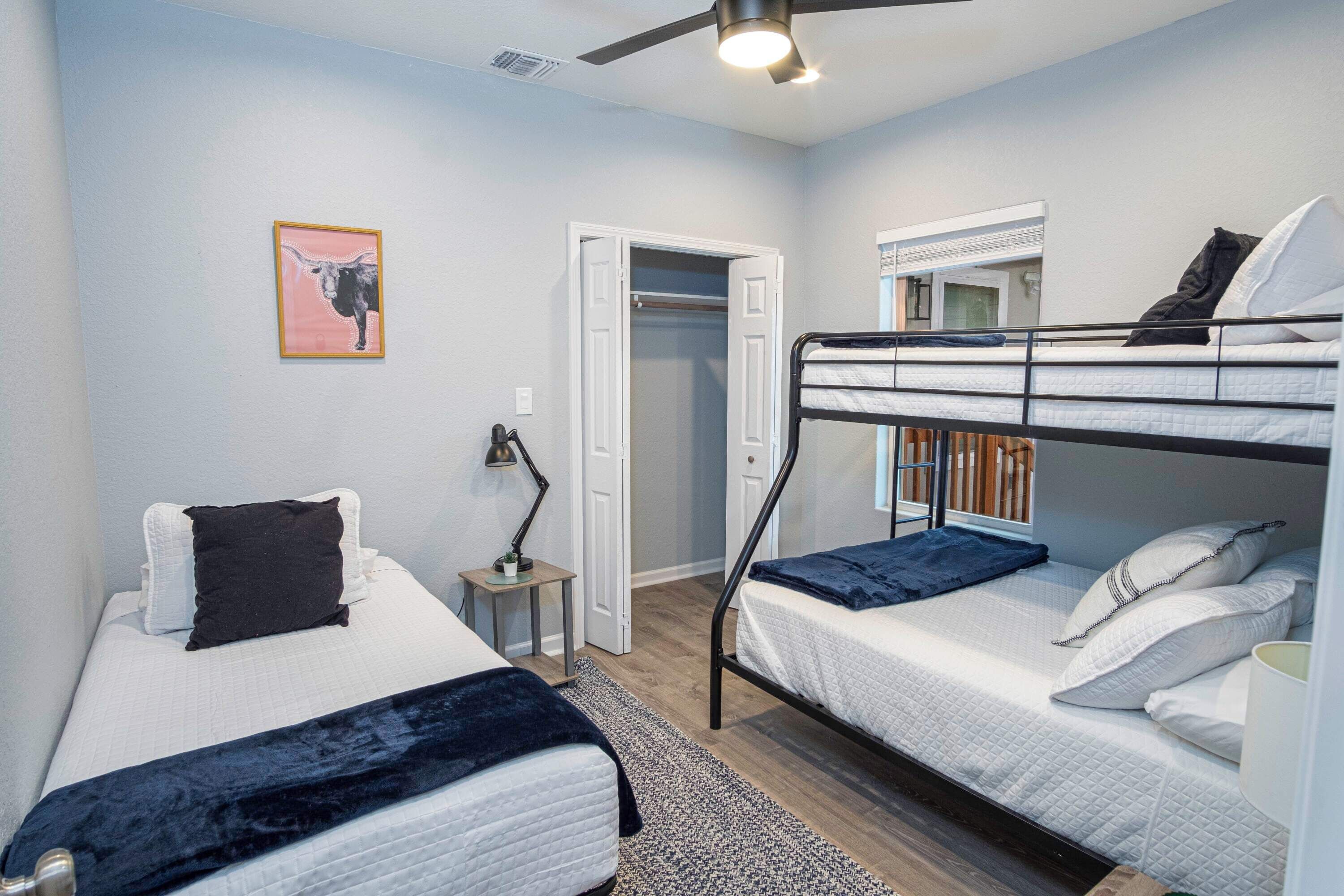 A bedroom with two beds, a closet, and a ceiling fan.