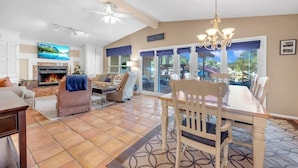 A spacious living area with a fireplace, a dining table, and comfortable seating.