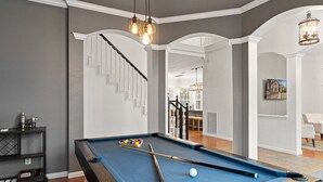Une table de billard recouverte d’un drap bleu, une queue de billard et une bille.