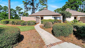 A two-story house with a covered porch, a driveway, and well-maintained landscaping.