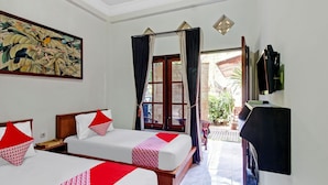 A hotel room with two beds, a large painting, a television, and a view of the outside.