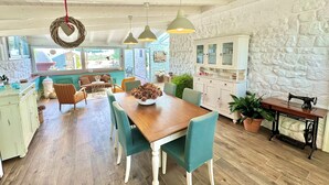 Una cocina amplia con pared de piedra, armarios de madera y una máquina de coser Singer antigua.