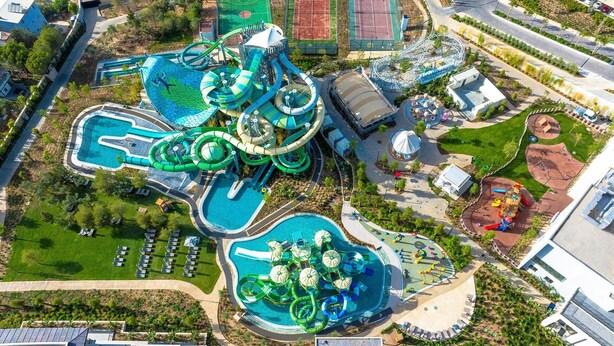 A water park with multiple pools, slides, and a playground area.