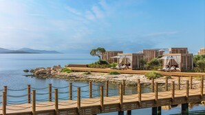 A coastal resort with wooden deck, lounge chairs, and cabanas overlooking the sea. - Anda Barut Collection - Ultra All Inclusive (Didim)