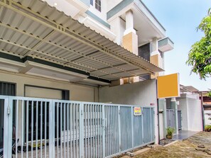 A residential building with a covered patio area, a gated entrance, and a signboard. - OYO 92479 Pasadena House (Semarang)