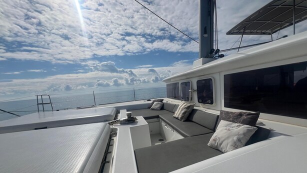 A yacht's deck with a seating area, large windows, and a view of the sea. - Ulysses Apartments Acropolis (Athens)