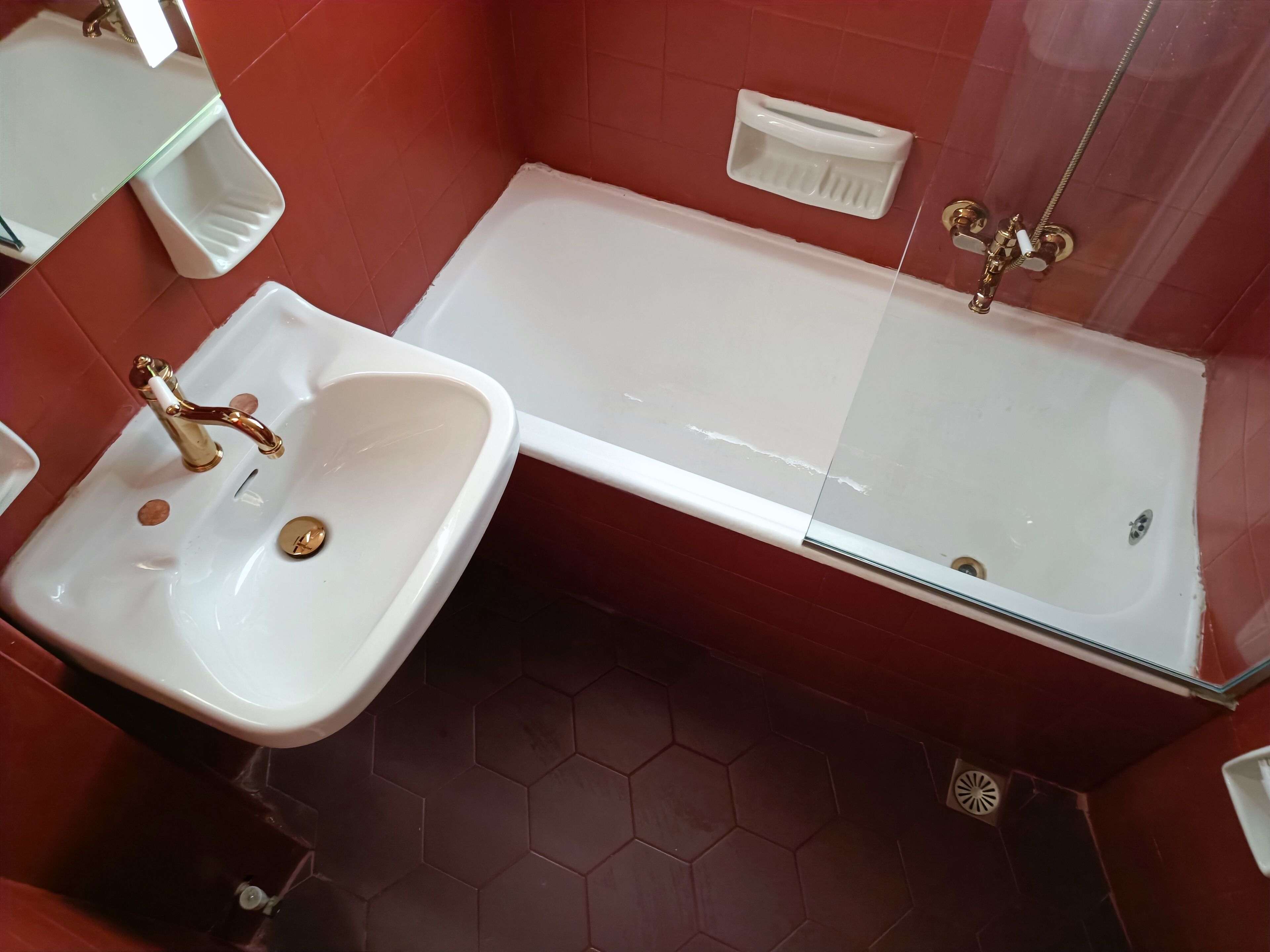 A bathroom with a white sink, a bathtub, and a glass shower enclosure.