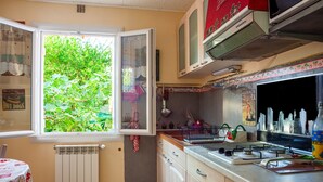 Una cocina con ventana, radiador y estufa.