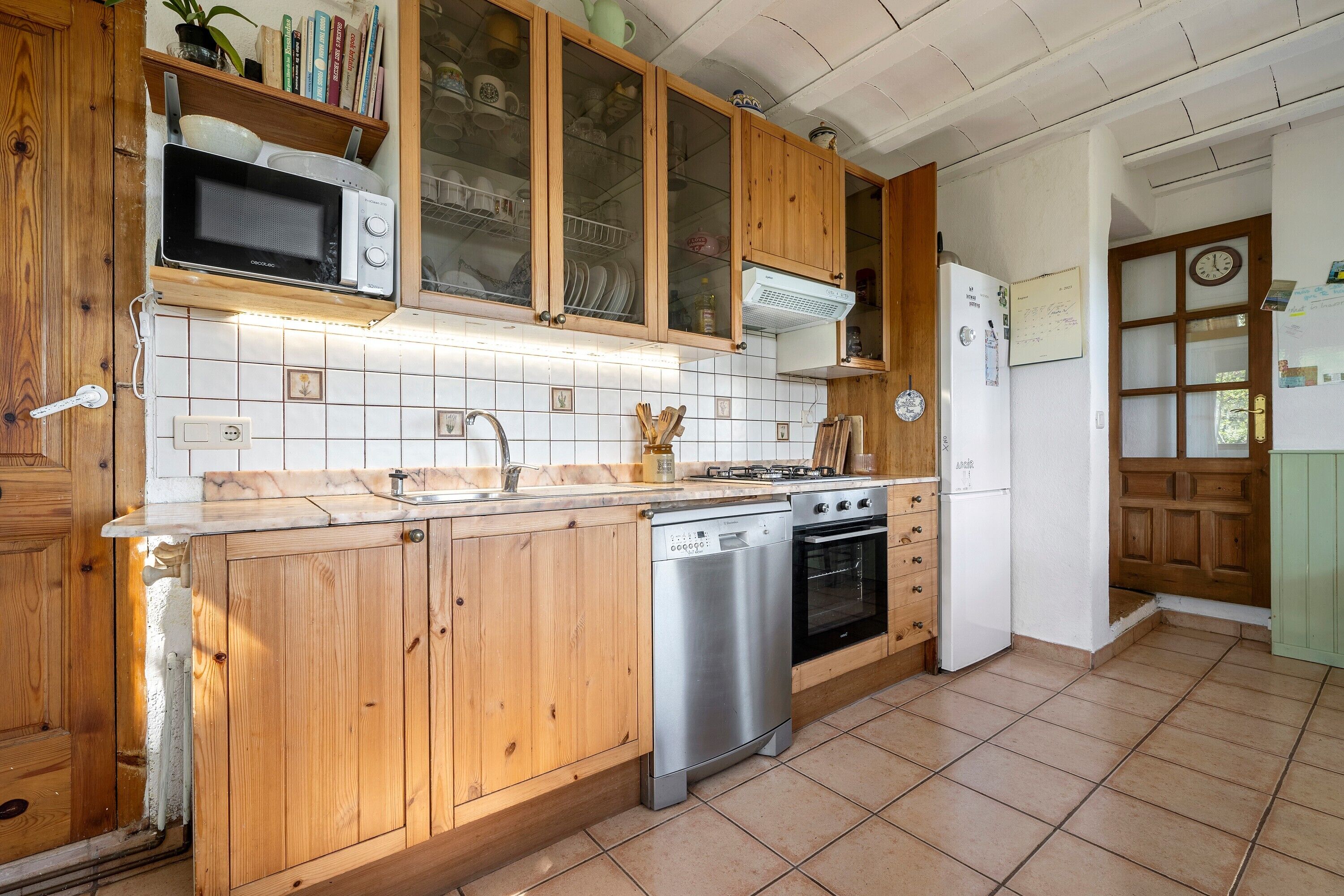 A kitchen with wooden cabinets, a microwave, a dishwasher, a stove, and a refrigerator.