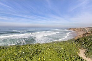 A coastal landscape with a beach, ocean waves, and vegetation. - Studio Apartment 'Estúdio Alto Da Praia' with Sea View, Shared Pool and Wi-Fi (Colares)