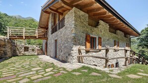 Une maison en pierre avec un balcon en bois et un escalier en pierre.