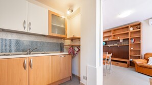 Una cocina moderna con armarios de madera, salpicadero de azulejos y una estantería empotrada.