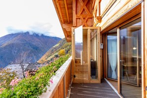 A wooden building with a glass door leading to a balcony overlooking a mountainous landscape. - Apartment 'Waldes Duft - Patleidhof' with Mountain View and Private Sauna on the Balcony (Naturns)