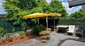 A patio area with a yellow umbrella, a wooden table, and a grill. - Studio Apartment "Bassin d'Arcachon" with Private Terrace & Wi-Fi (La Teste-de-Buch)