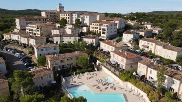 A resort with multiple buildings, a swimming pool, and a mountainous backdrop. - Spacious 22 m2 Studio in the Village Center n1 (Charleval)