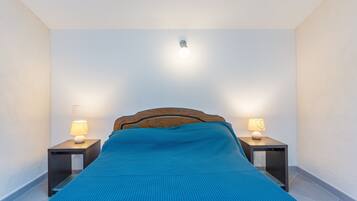 2 dormitorios y tabla de planchar con plancha