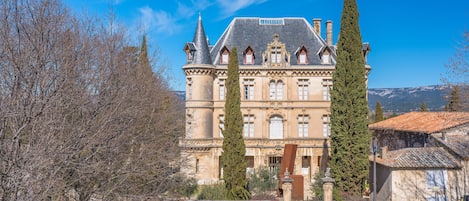 A large, historic building with a symmetrical facade, multiple windows, and a prominent central tower.