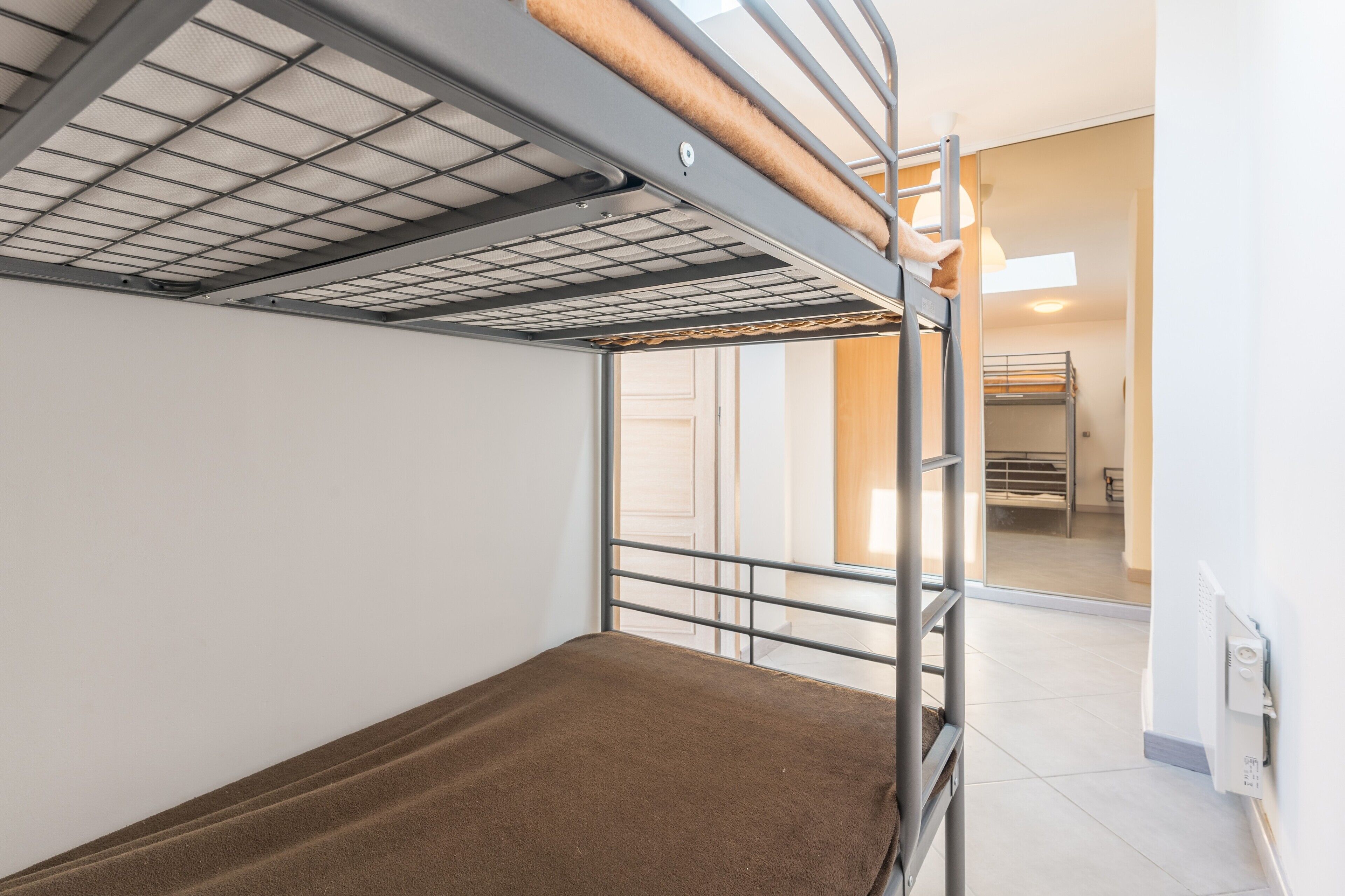 A bunk bed with a metal frame, a mattress, and a headboard.