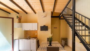 A modern kitchen with white cabinets, a wooden ceiling, and a black staircase. - Apartment 'Simone' with Wi-Fi and Air Conditioning (alezio)