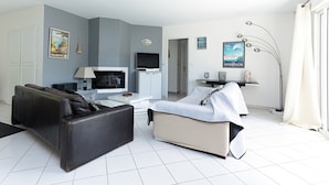 Un salon moderne comprenant un canapé, un téléviseur, une table basse et un lit.