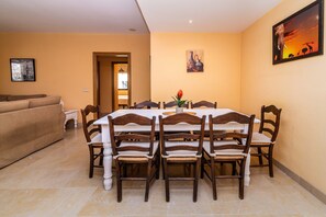 Un área de comedor con una mesa, sillas, un sofá y un cuadro en la pared.