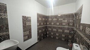A bathroom with patterned tiles, a toilet, a sink, and a shower.