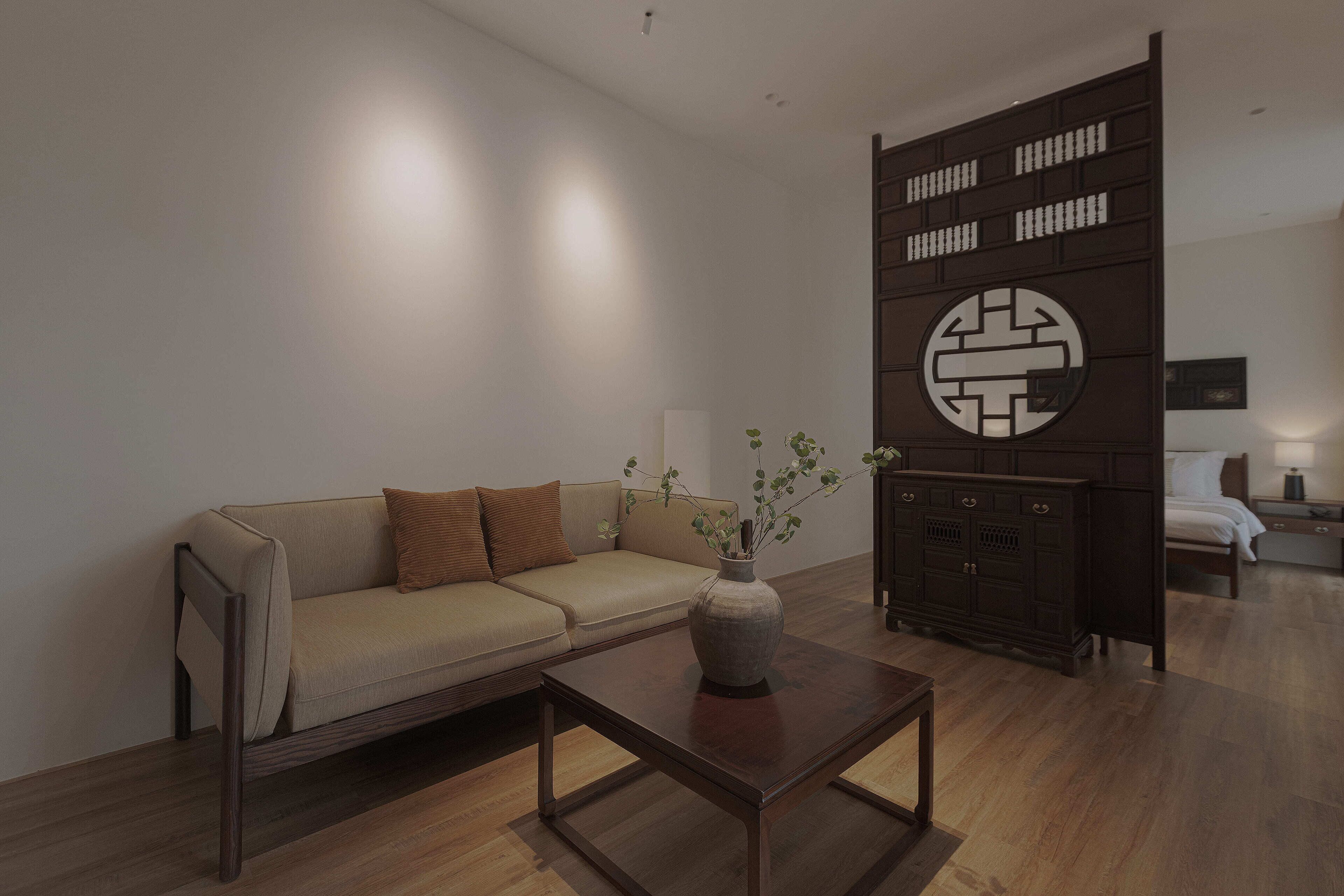 A modern living room with a sofa, a coffee table, and a decorative cabinet.