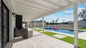 A covered patio with a pool, outdoor furniture, and a view of the surrounding landscape. - Petey's Paradise in the Heart of Scottsdale (Scottsdale)