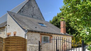 A rustic house with a stone exterior, a wooden gate, and a metal fence. - Charming Cottage in Orchard with Modern Amenities & Scenic Views (Joué-lès-Tours)