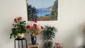 A room with a view of the sea, a wicker lamp, a wooden stool, and various potted plants. - Quiet downtown apartment (Rodez)
