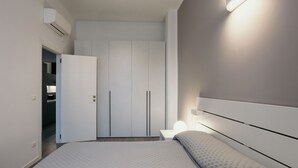A modern bedroom with a bed, bedside table, and a wardrobe. - GuestHost - Studio 1 is the best you could wish for in Bologna, a comfortable and beautiful home. It's a spacious, renovated and stylishly furnished two-room apartment, bright and airy, perfect for a couple or four friends. It's close to the highway and  (Bologna)