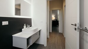 A modern bathroom with a white sink, dark wall, and a mirror. - GuestHost - Studio 1 is the best you could wish for in Bologna, a comfortable and beautiful home. It's a spacious, renovated and stylishly furnished two-room apartment, bright and airy, perfect for a couple or four friends. It's close to the highway and  (Bologna)