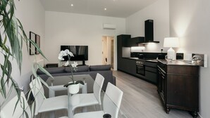 A modern living room with a dining area, a kitchen, and a TV. - GuestHost - Studio 1 is the best you could wish for in Bologna, a comfortable and beautiful home. It's a spacious, renovated and stylishly furnished two-room apartment, bright and airy, perfect for a couple or four friends. It's close to the highway and  (Bologna)