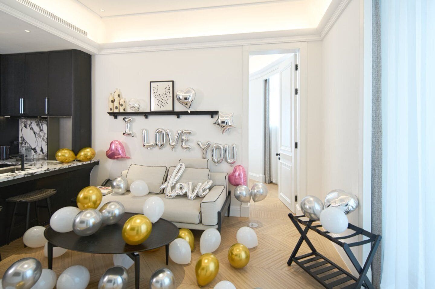 Ein modernes Wohnzimmer mit einer Couch, Luftballons und Wanddekoration.