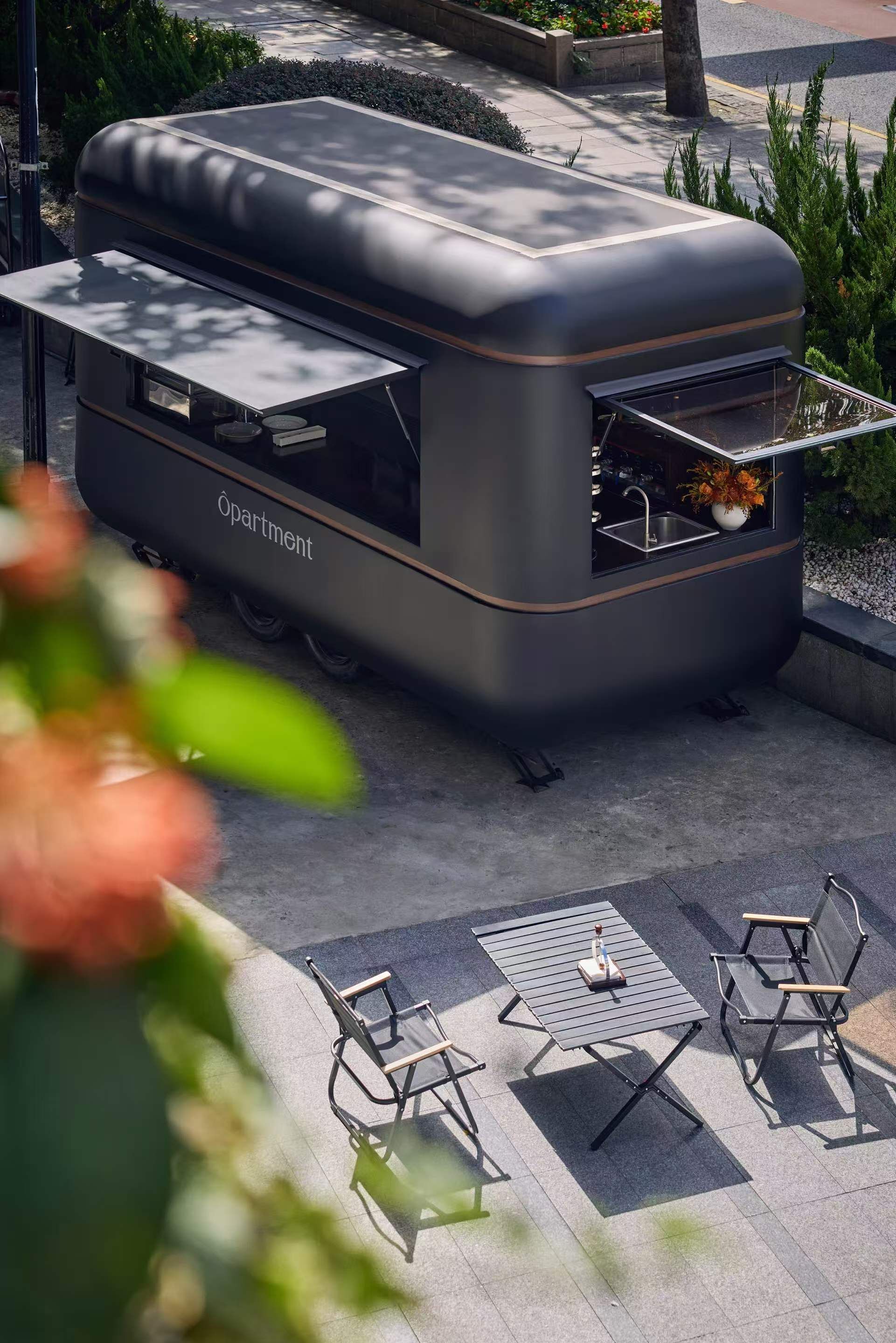 Une cuisine extérieure moderne, dotée d’un évier encastré et d’un petit plan de travail, entourée d’un espace salon extérieur.