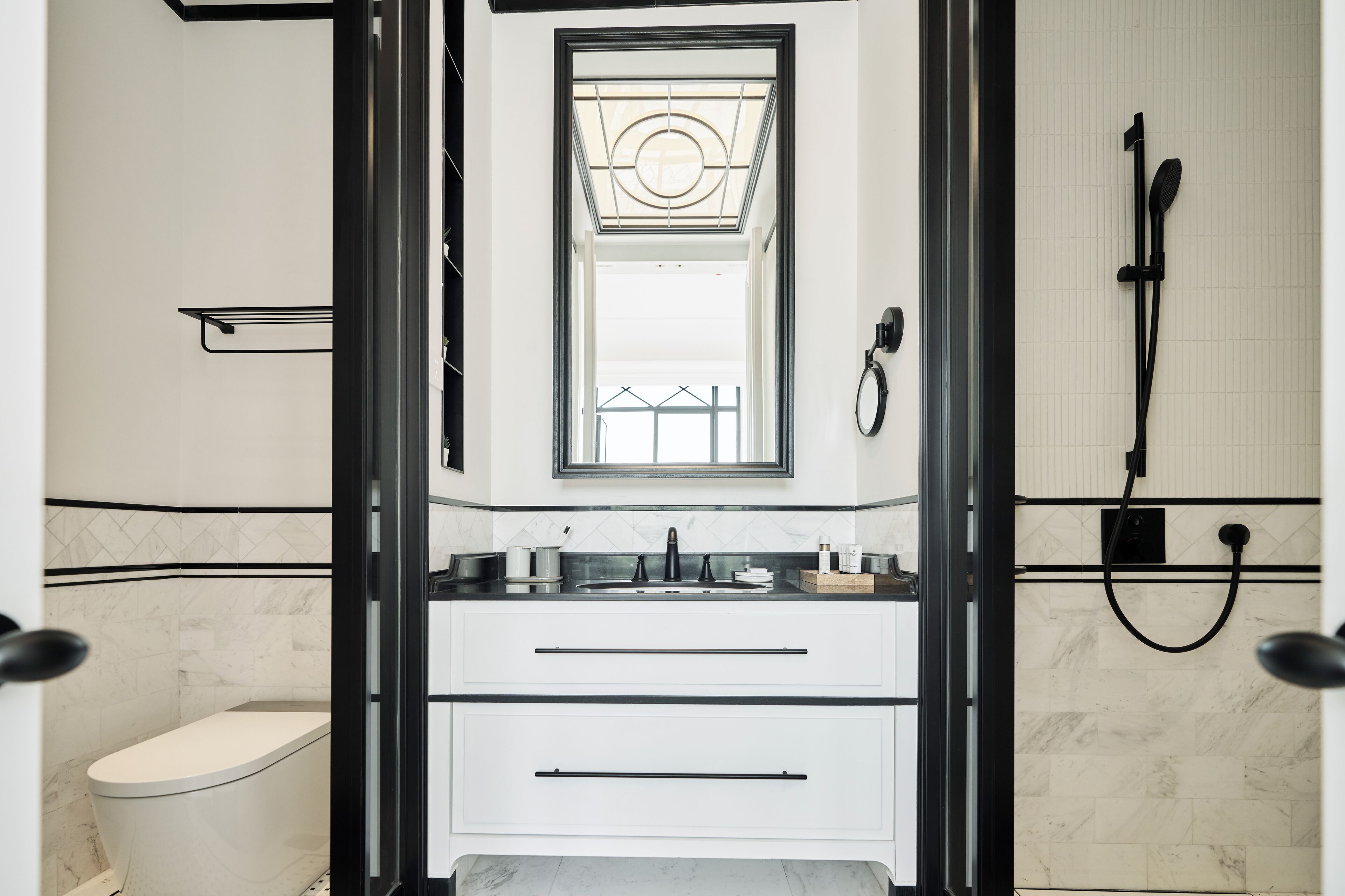 Une salle de bain moderne équipée de toilettes, d’un lavabo et d’une douche.