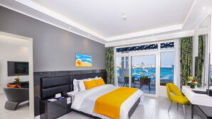 A modern hotel room with a large bed, a desk, and a view of the sea. - Naama Bay Suites & Spa (Sharm El Sheikh)