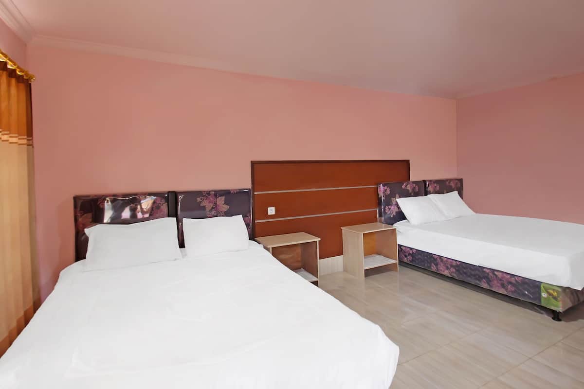 Ein Hotelzimmer mit zwei Einzelbetten, Holz-Kopfteilen und einem kleinen Nachttisch.