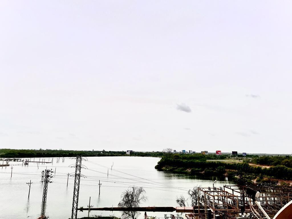 A river with industrial structures and power lines.