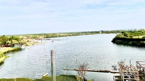 A river with a bridge and greenery on the banks. - HOTEL SITA GRAND (Hyderabad)
